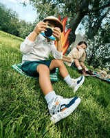 Niño con tenis Audaz jugando al aire libre y tomando fotos. Pisa Fuerte, calzado cómodo y con estilo para cada aventura.