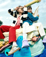 Niñas con tenis Coqueta dorados y lilas disfrutando al aire libre. Pisa Fuerte, moda infantil que combina estilo y diversión.
